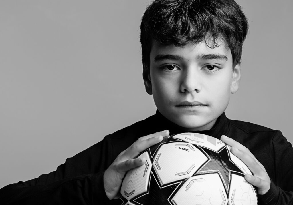 Modern portrait of a boy with a soccer ball. 